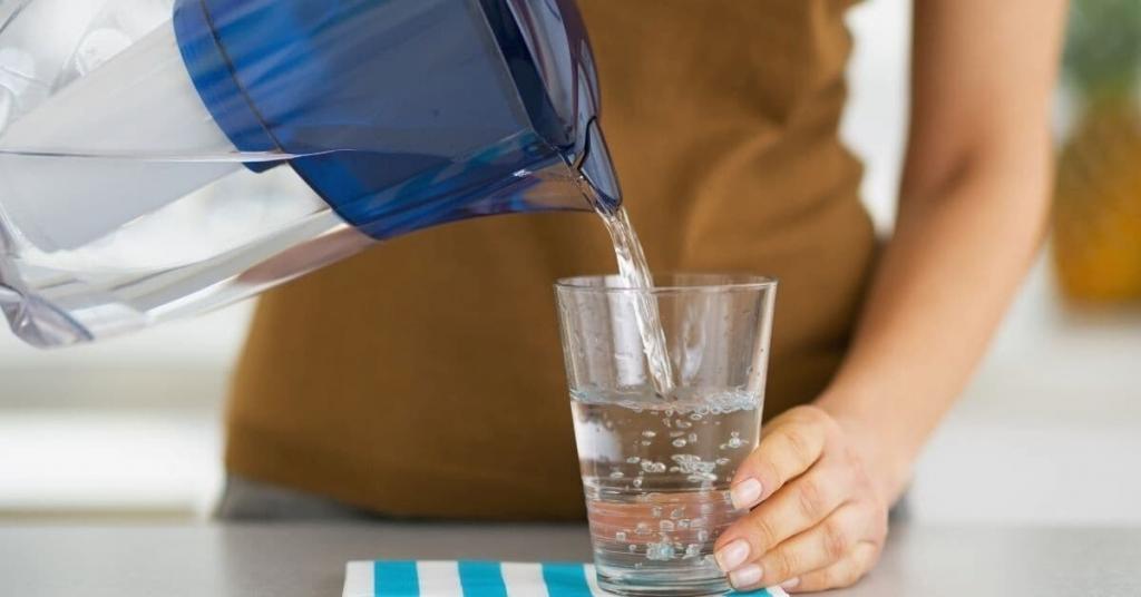 woman filling glass with filtered water